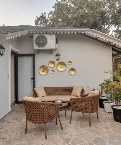 Outdoor seating area with chairs around a table and potted plants towards the side at Lime Tree Villa with Private Pool | Luxury Stay in Goa.
